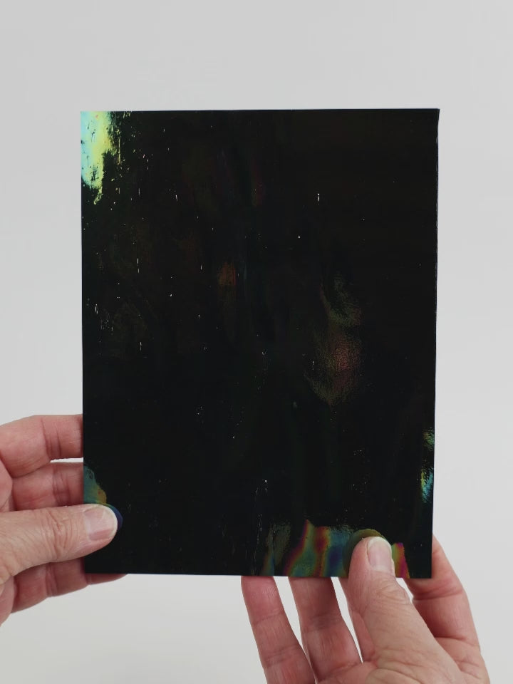 Video of the Black Iridescent glass plate in black, opaque and iridescent finish, 15x19cm, held up and tilted to show its pattern and transparency.
