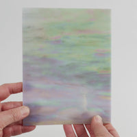 Video of the grey pink iridescent glass plate in grey pink translucent iridescent, 15x19cm, held up and tilted to show its pattern and transparency